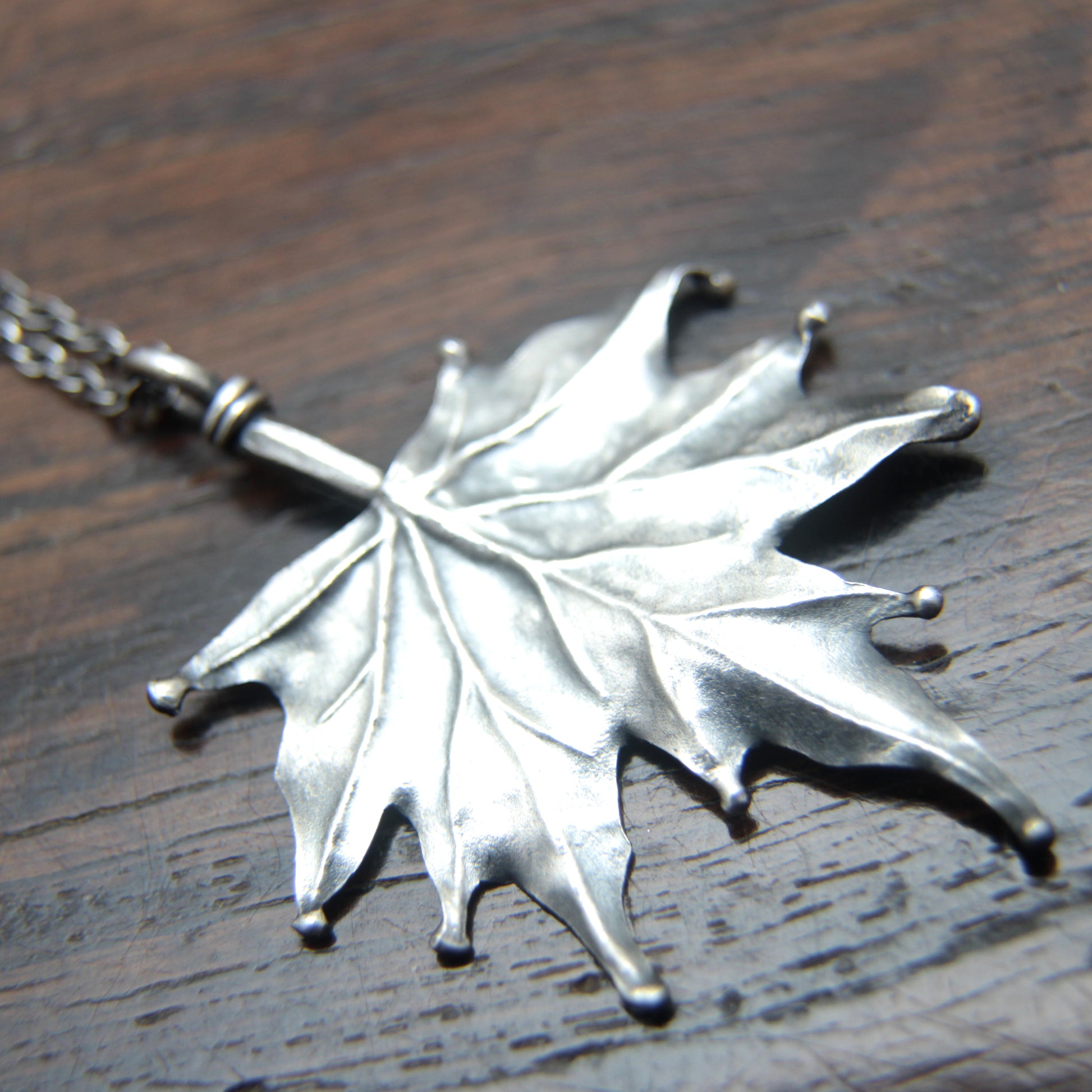 Closeup photo of Sterling silver Maple pendant designed and made by M Barran at Taitaya Forge