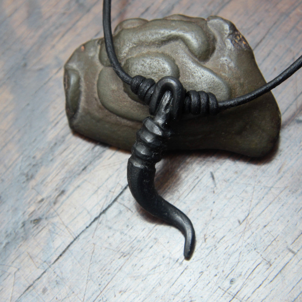 A forged iron cornicello, Italian horn, pendant with a black finish, on a black leather cord, designed and made by M Barran at Taitaya Forge.