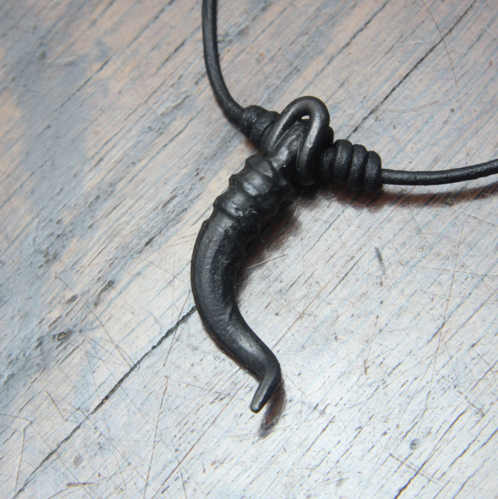 A forged iron cornicello, Italian horn, pendant with a black finish, on a black leather cord, designed and made by M Barran at Taitaya Forge.