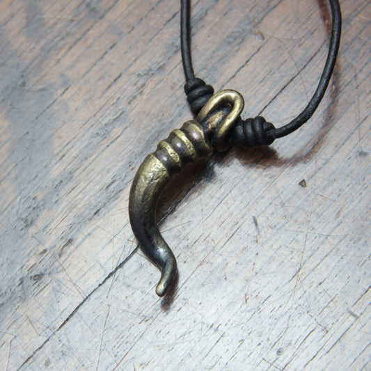 A forged iron cornicello, Italian horn, pendant with a antique bronze finish, on a black leather cord, designed and made by M Barran at Taitaya Forge.
