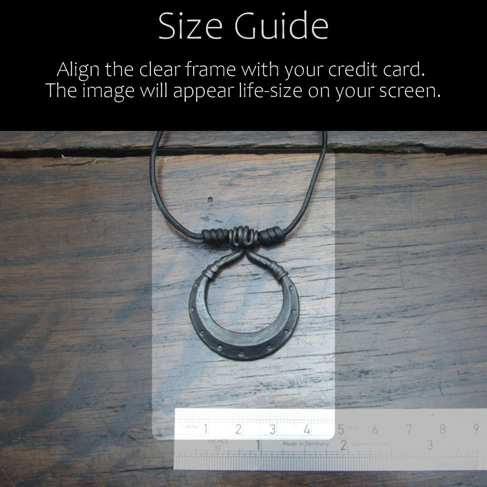 Handforged iron moon pendant made by taitaya forge, size guid in comparison with a credit card and ruler