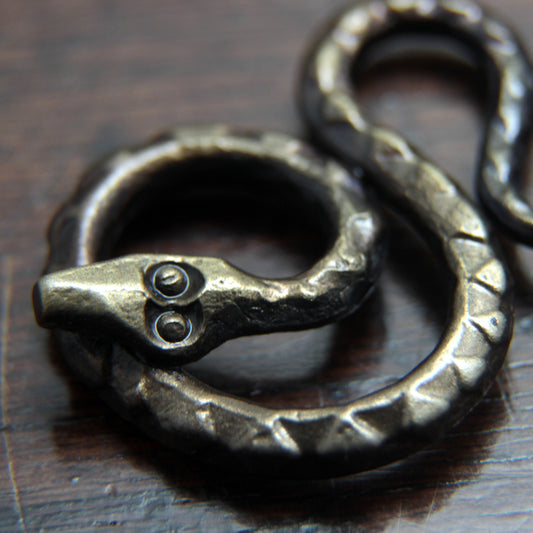 Forged iron snake pendant, detail close photo of the stamp work decoration