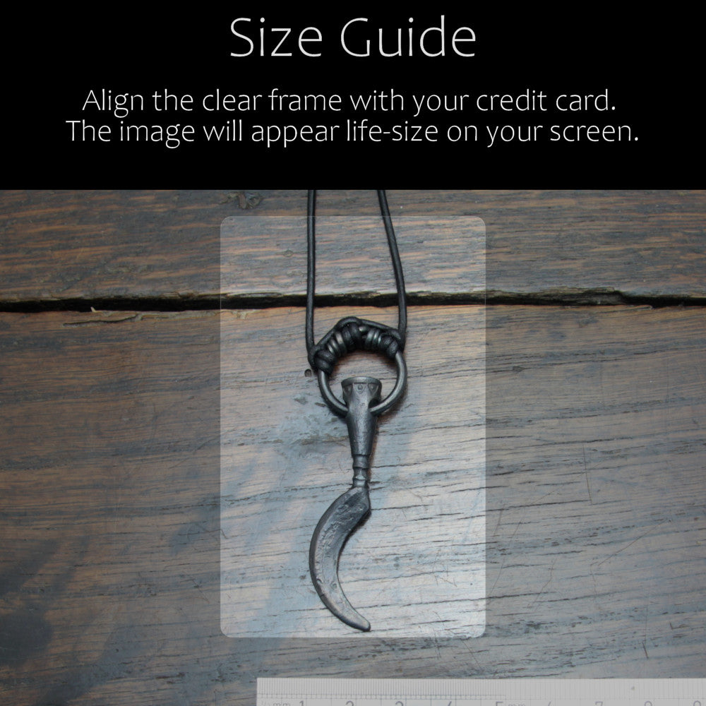 Handforged iron sickle pendant made by taitaya forge, size guid in comparison with a credit card and ruler