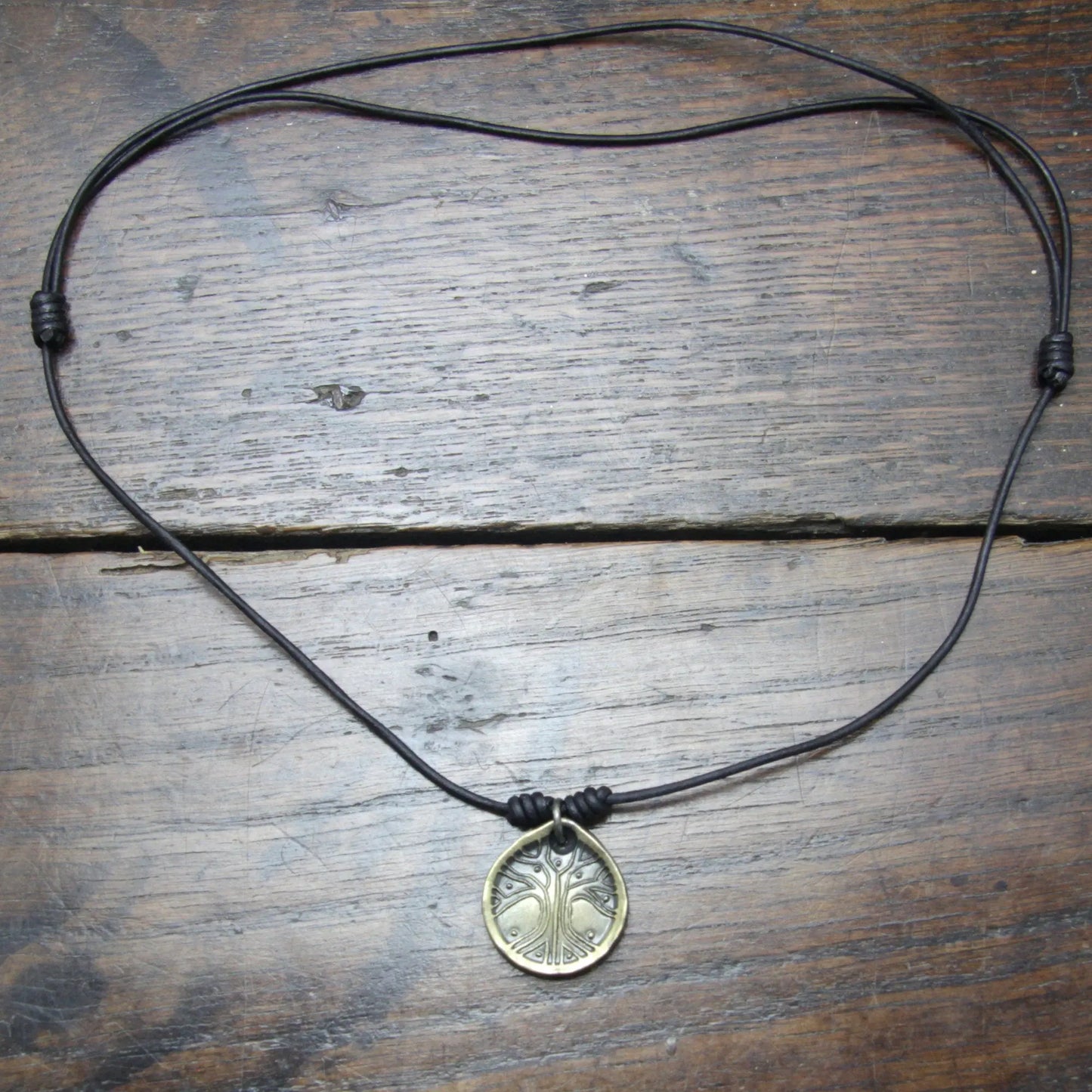 Norse Viking Yggdrasil Tree Iron Coin Pendant on a leather necklace.