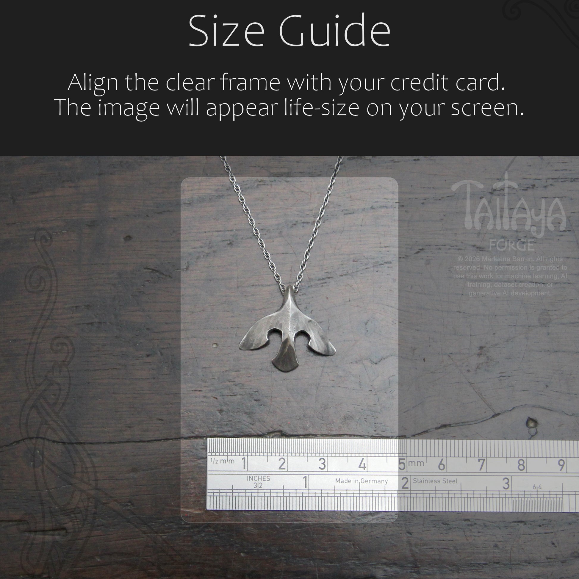Silver raven pendant necklace displayed on a clear measurement card over a dark wood background, with a ruler at the bottom and a black header reading 'Size Guide' and instructions about aligning the frame with a credit card.