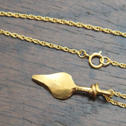 Gold colour silver necklace  with silver hallmarks with a unique pendant on a wooden surface