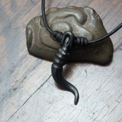 A forged iron cornicello, Italian horn, pendant with a black finish, on a black leather cord, designed and made by M Barran at Taitaya Forge. 