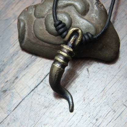 A forged iron cornicello, Italian horn, pendant with a antique bronze finish, on a black leather cord, designed and made by M Barran at Taitaya Forge. 