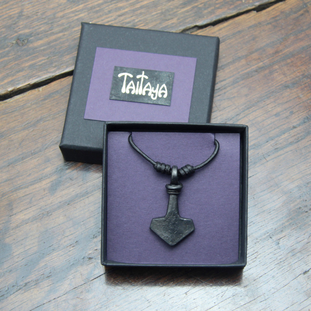 Taitay Forge iron Thor's hammer mjolnir pendant with a looped handle presented in a black gift box with gold embossed logo and a purple card insert. 