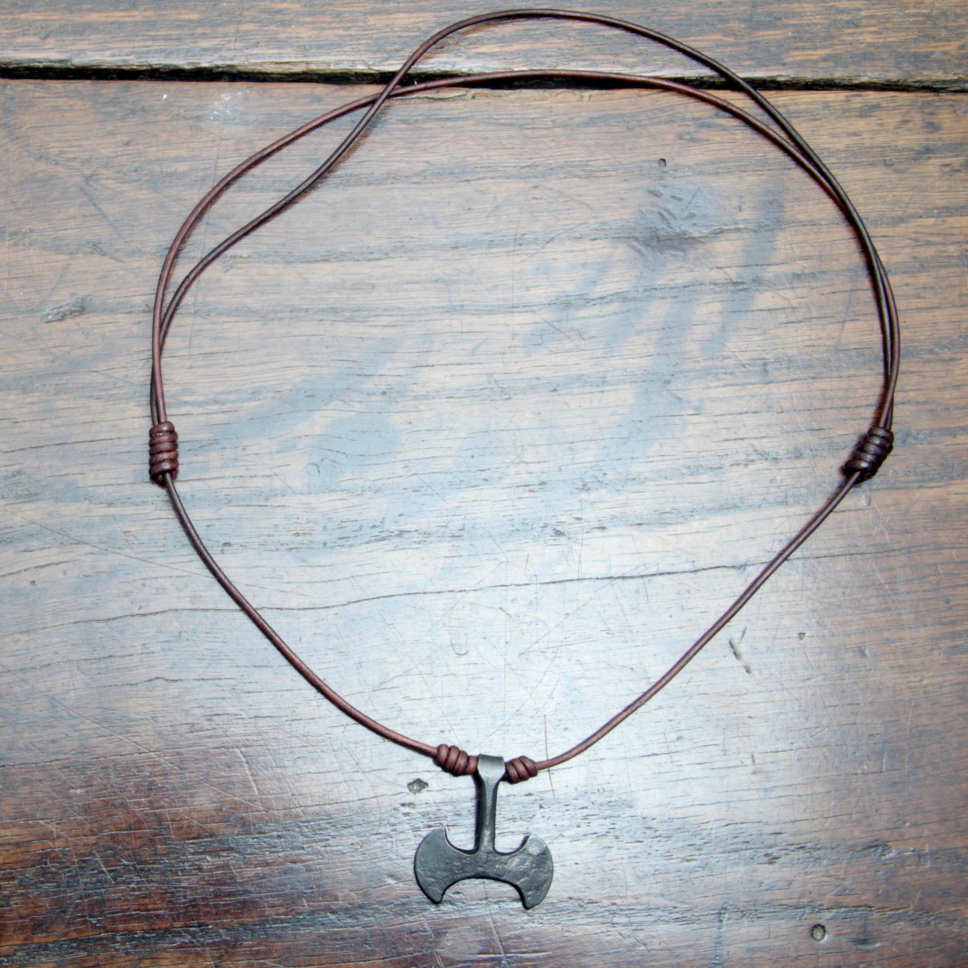 flat lay picture of the  whole Taitaya Forge iron Labrys pendant.