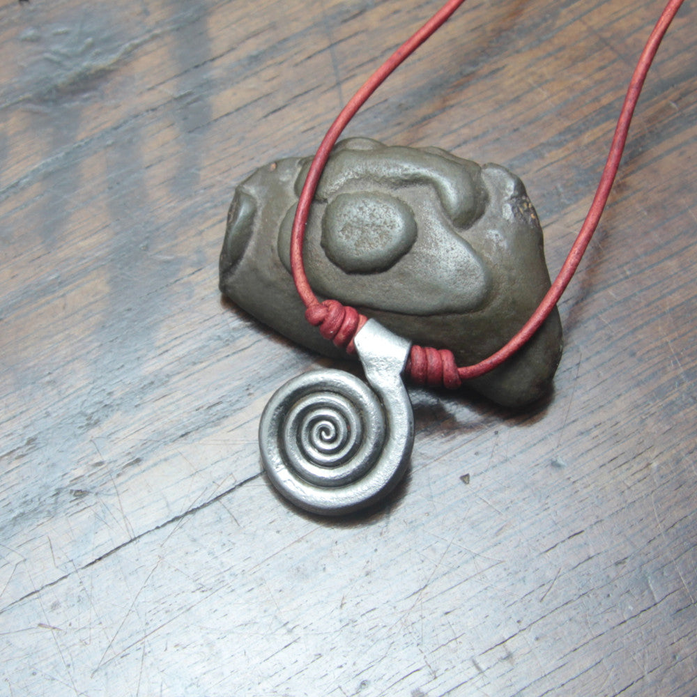 Forged iron spiral pendant, finished in a silver colour, attached onto a red leather cord. 