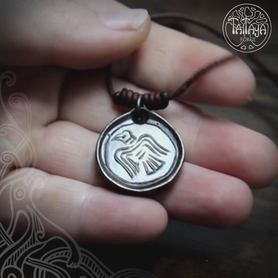 video of a hand holding the Viking Raven Iron Coin Necklace, made by Luke Barran at Taitaya Forge, UK