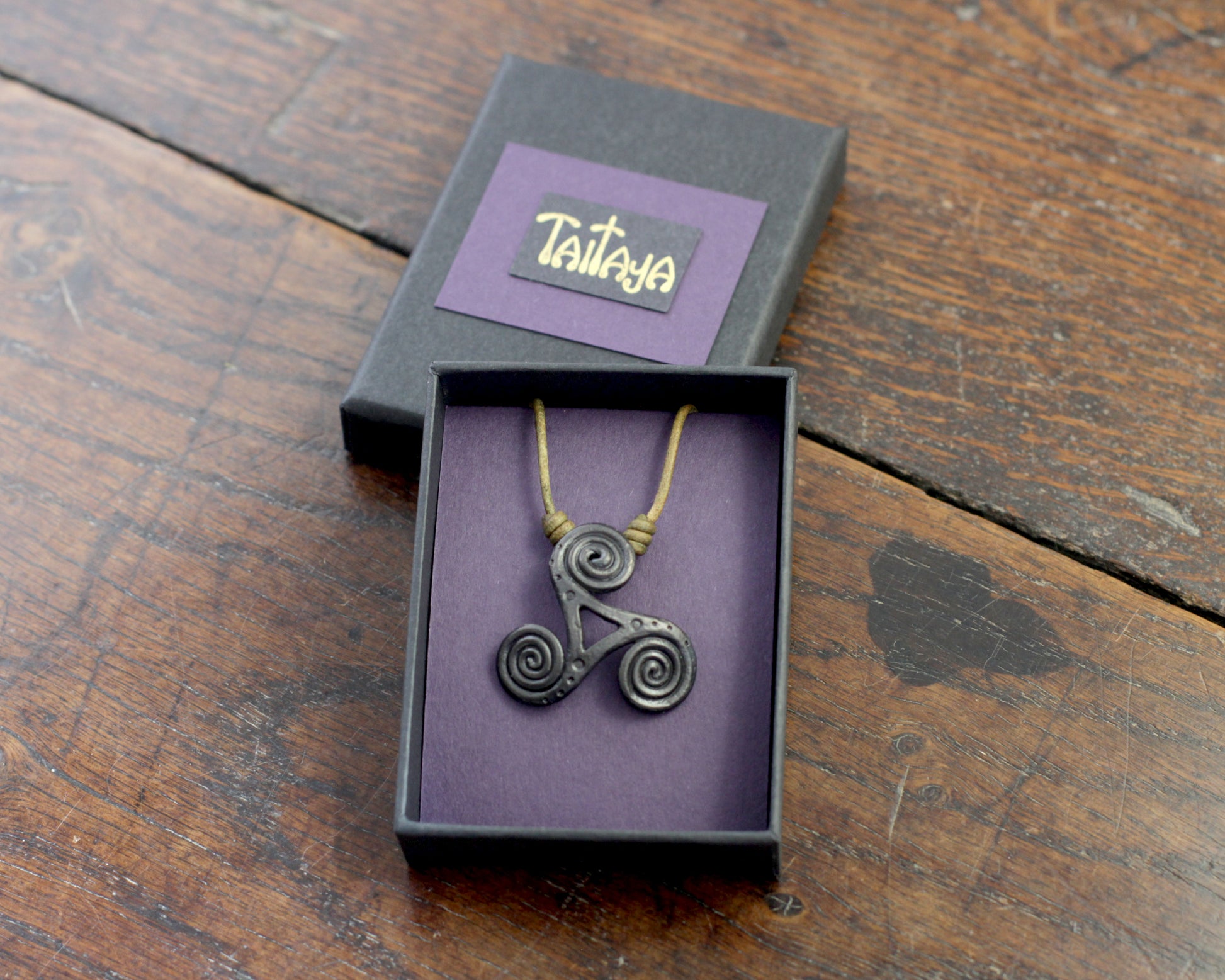 Hand Forged Iron Triskelion Necklace, designed and made by Blacksmith Marleena Barran from Taitaya Forge.  Presented in a Purple Gift Box