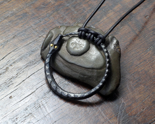 Hand forged Pure iron Ourboros with solid gold eyes. Pendant on a leather cord, made and designed by M.Barran Taitaya Forge, UK