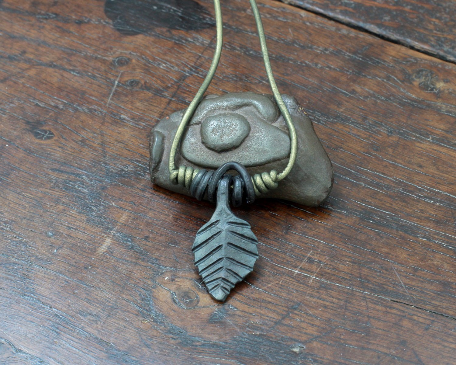 Medium forged iron leaf pendant on a green leather cord